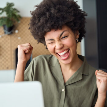 Young woman winner looking at laptop computer. Excited euphoric girl student celebrating good exam result, university admission, internet victory success winning online.