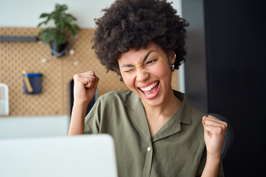 Young woman winner looking at laptop computer. Excited euphoric girl student celebrating good exam result, university admission, internet victory success winning online.