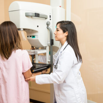 Doctor helping patient get a mammogram