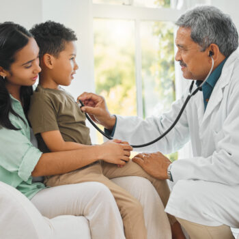 shot of a mature doctor doing a checkup on a little boy at home