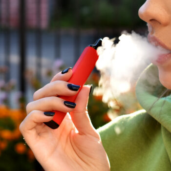 young woman using e-cigarette