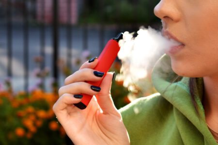 young woman using e-cigarette