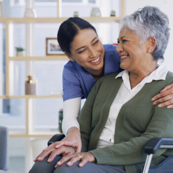 Happy, caregiver and old woman in wheelchair at house for assistance, medical advice and homecare. Smile, nurse and senior person with disability of support, healthcare trust and patient consultation