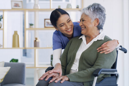 Happy, caregiver and old woman in wheelchair at house for assistance, medical advice and homecare. Smile, nurse and senior person with disability of support, healthcare trust and patient consultation