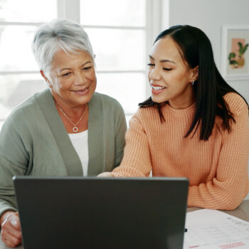 Mother and daughter viewing resources on laptop.