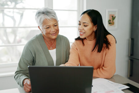 Mother and daughter viewing resources on laptop.