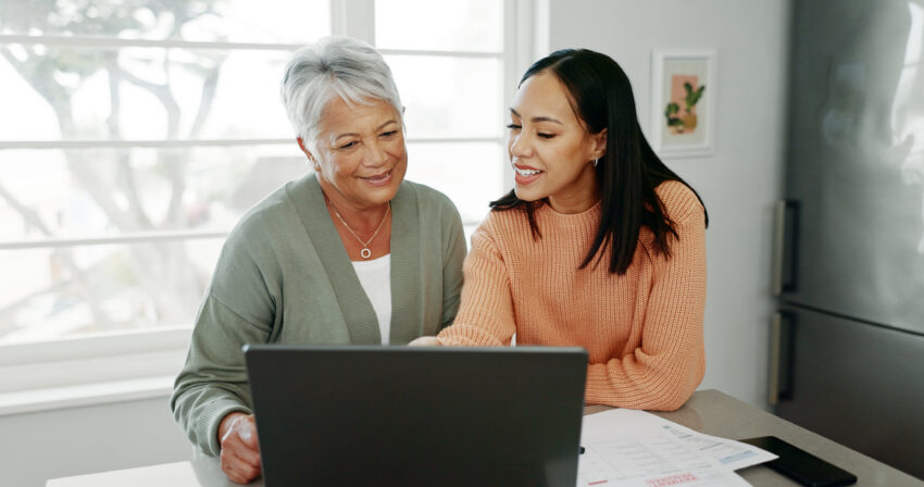 Mother and daughter viewing resources on laptop.