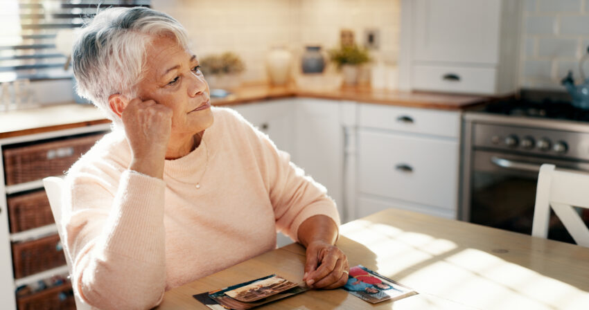 Thinking, senior woman and picture at house for mourning loss, memory past and reminder for history. Elderly person, grief and old image with loneliness, remember partner and nostalgia for retirement