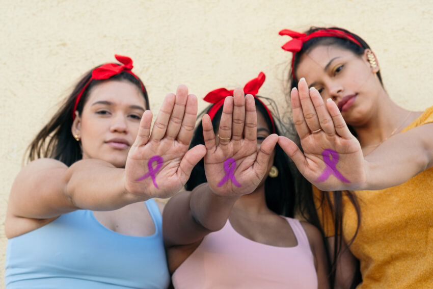 Three Women with symbol of breast cancer drawing on hand