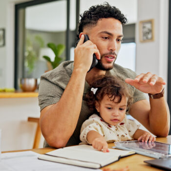 Father working at computer with child.