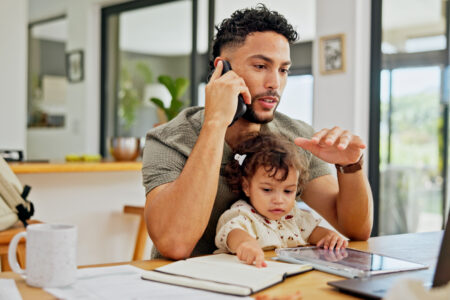 Father working at computer with child.