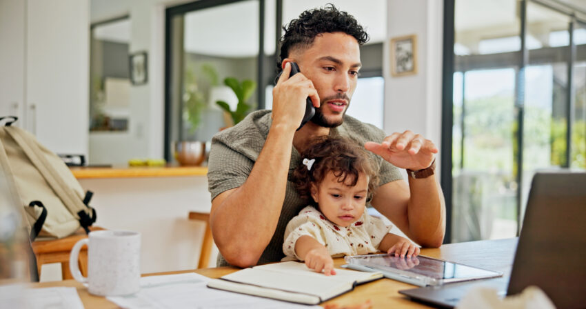 Father working at computer with child.