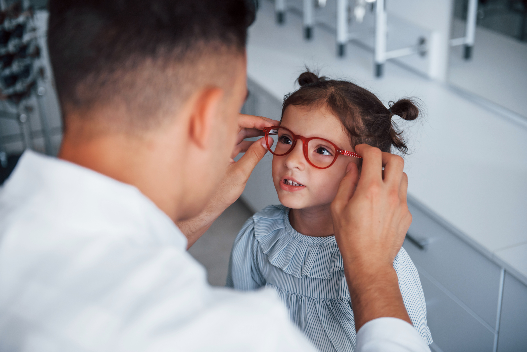 Child receiving glasses during eye exam. 