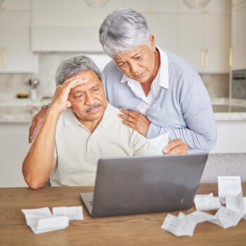 Stress, senior couple and laptop with finance paper and taxes for financial security investment. Sad, depression or mental health anxiety while planning retirement budget or insurance funeral savings