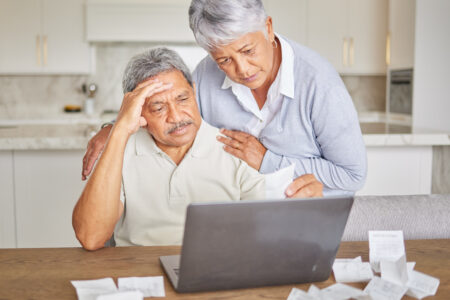 Stress, senior couple and laptop with finance paper and taxes for financial security investment. Sad, depression or mental health anxiety while planning retirement budget or insurance funeral savings