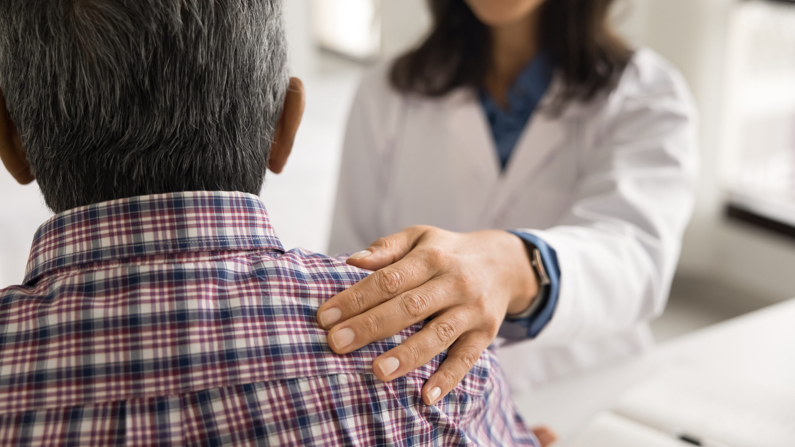 Close up cropped view unknown female doctor touch shoulder of aged male patient, giving psychological support, share good news, encouraging before procedure or operation, expressing warmth and care