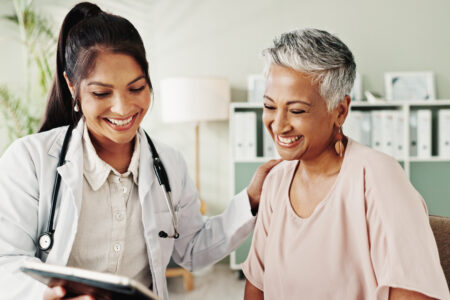 Smile, doctor and senior patient on tablet in office for good news, research and online results of diagnosis. People, digital and healthcare report, insurance checklist and treatment plan and medical